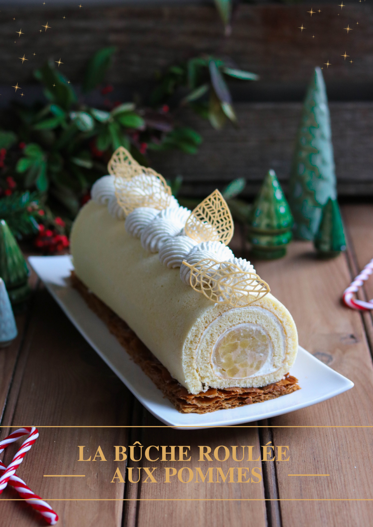 Une biscuit roulé garni avec un insert de pommes caramélisées et de la chantilly. Sur le dessus, la bûche est décorée avec de la chantilly pochée et des feuilles en pâte à cigarette.