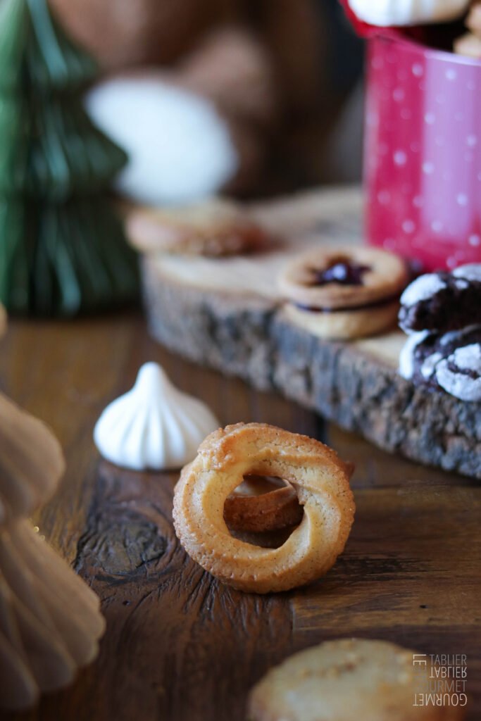 Des biscuits viennois circulaires et en gros plan, en bas d'une boîte à biscuits