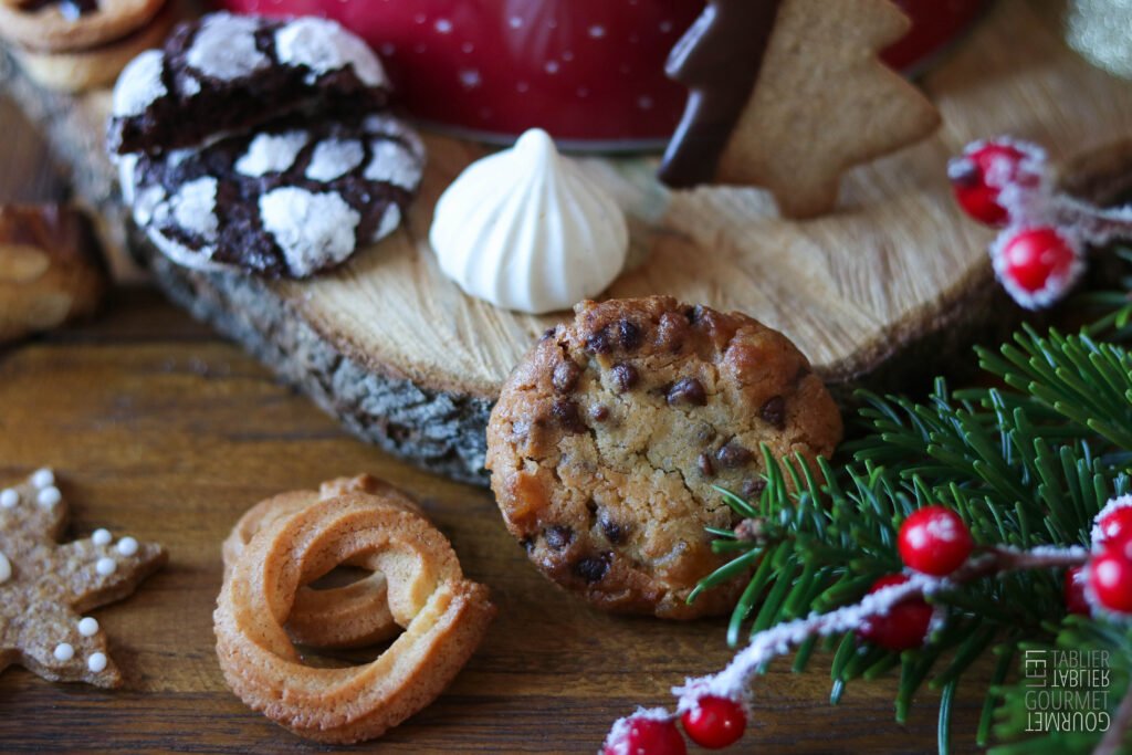 Des petits cookies chocolat/orange entourés de plein de biscuits et de branches de sapin