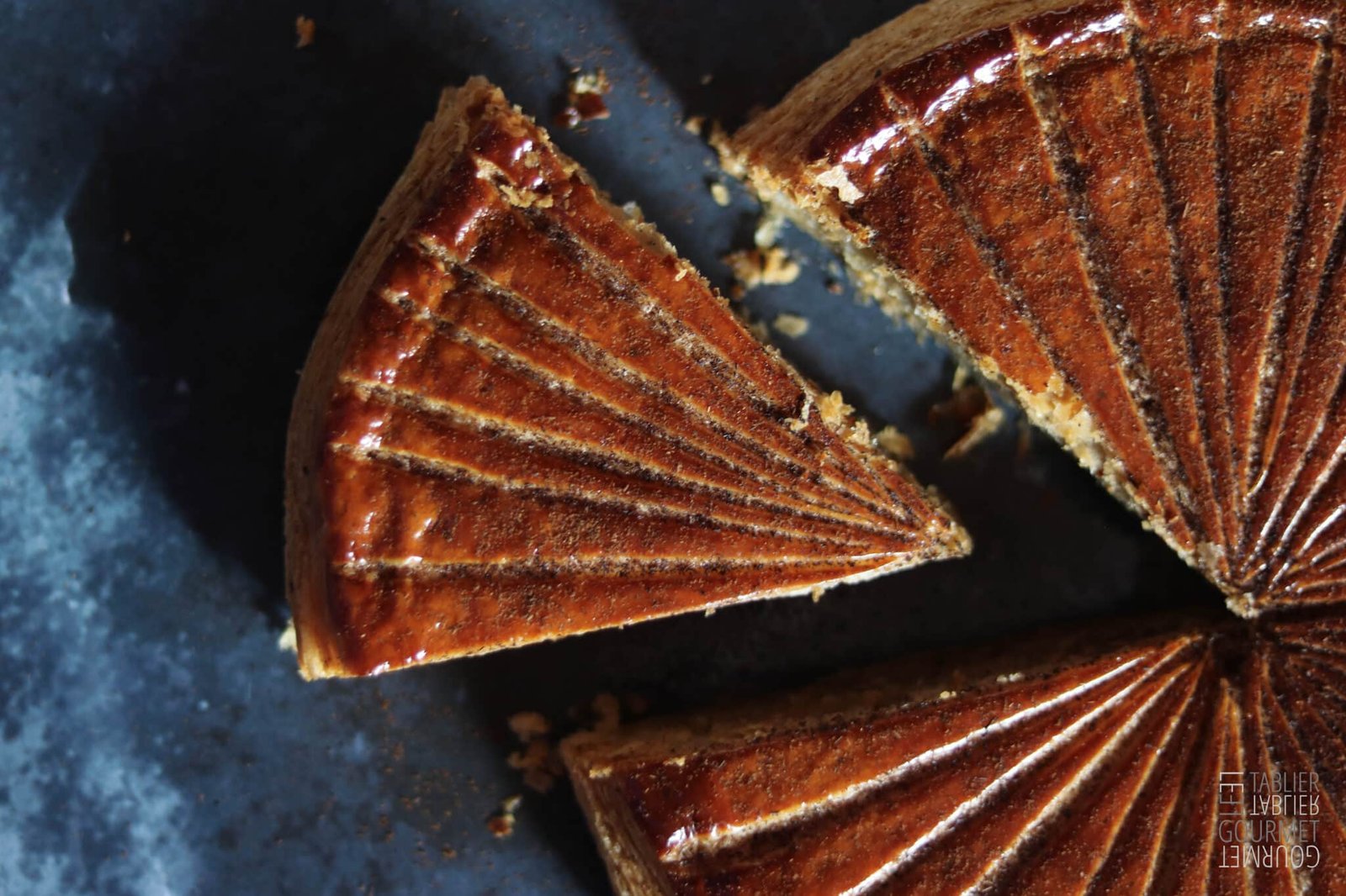 Une part de galette frangipane coupée et vue de dessus 