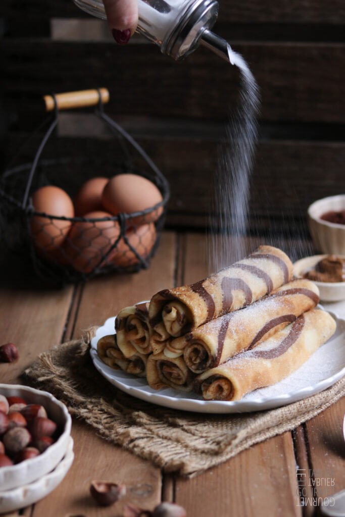 Des crêpes au cacao et à la noisette généreusement saupoudrées de sucre pour le goûter