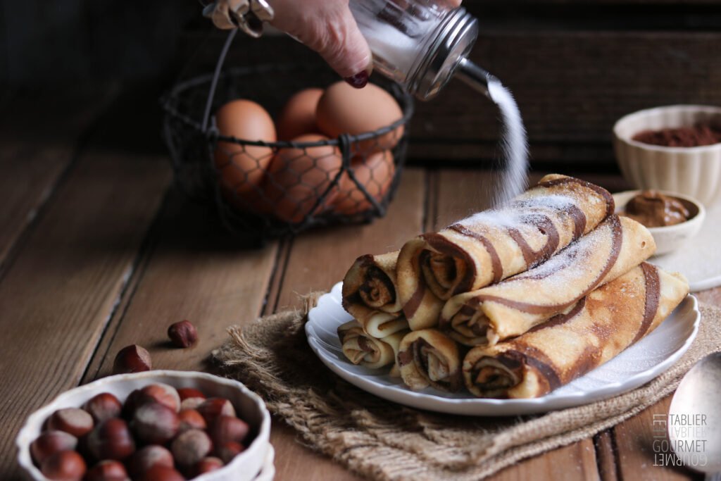 Des crêpes zébrées au cacao et à la noisettes saupoudrées de sucre