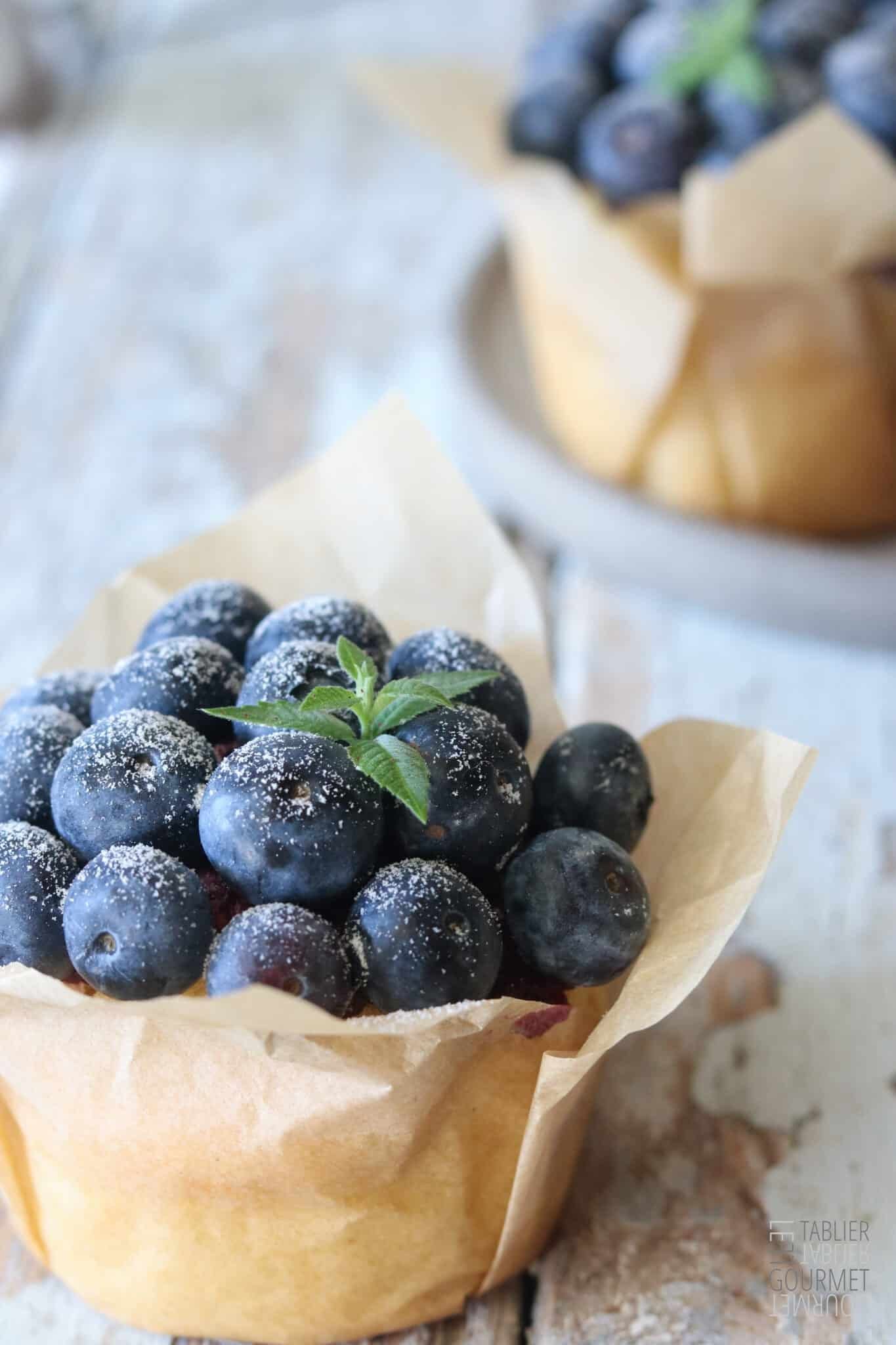Zoom sur un muffin bien moelleux et recouverts de myrtilles fraiches et d'un brin de menthe